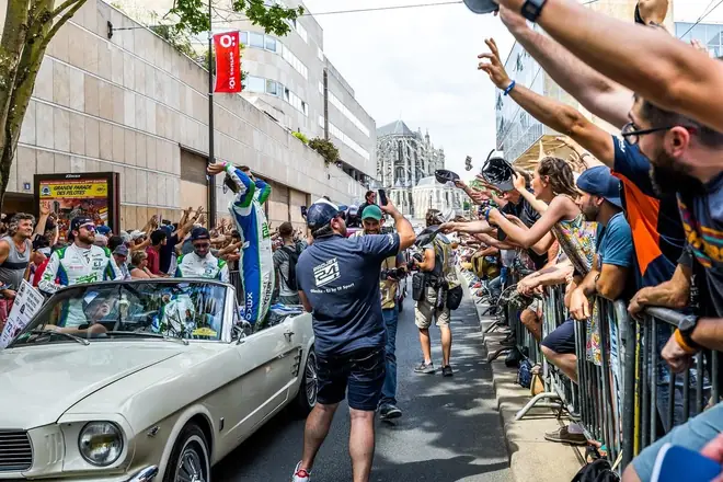 Parade des pilotes : le public tend les bras vers une voiture ancienne