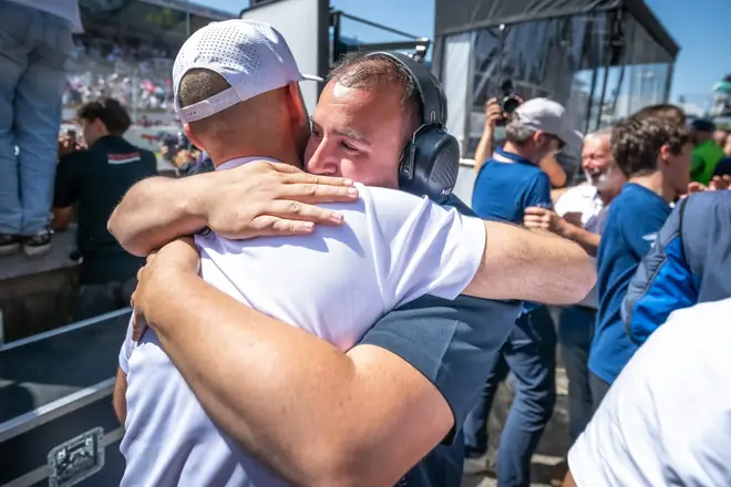 Accolade entre un pilote et un membre de l'équipe