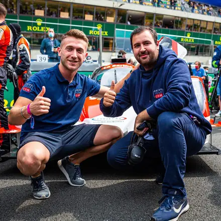 Deux membres de l'équipe, pouce levé, devant un prototype